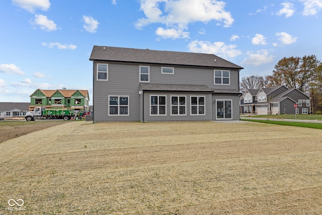 back of property with a garage and a yard