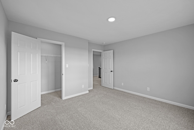 unfurnished bedroom featuring a closet and light carpet