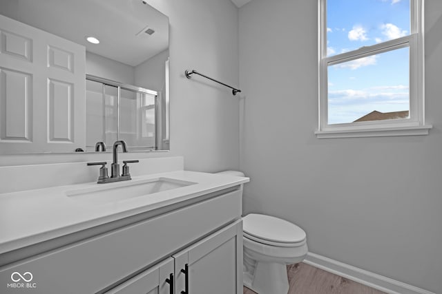 bathroom with an enclosed shower, plenty of natural light, vanity, and hardwood / wood-style flooring