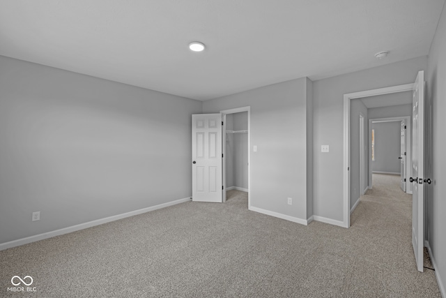 unfurnished bedroom featuring light carpet and a closet