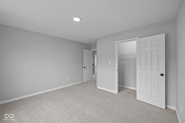 unfurnished bedroom featuring light carpet and a closet