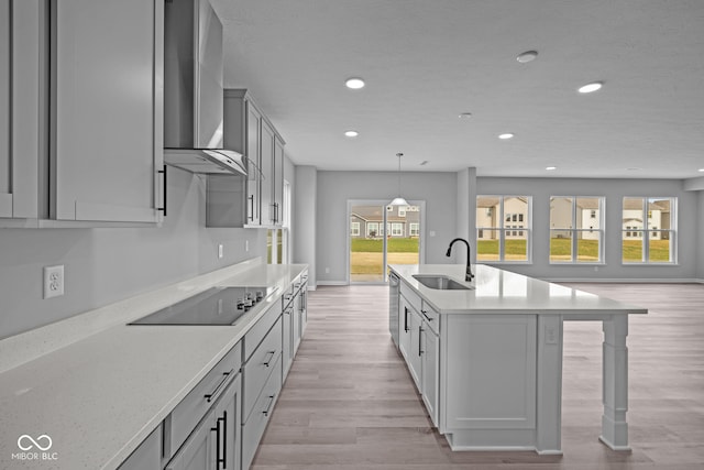 kitchen featuring gray cabinets, sink, light hardwood / wood-style floors, black electric cooktop, and wall chimney exhaust hood