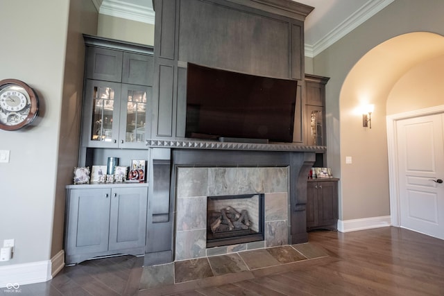 unfurnished living room featuring a tile fireplace, crown molding, and dark hardwood / wood-style flooring