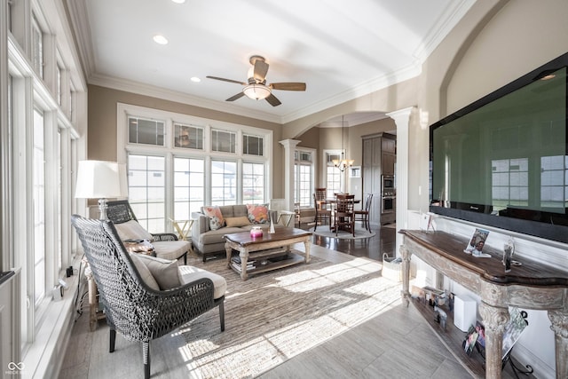 sunroom / solarium with ornate columns and ceiling fan with notable chandelier