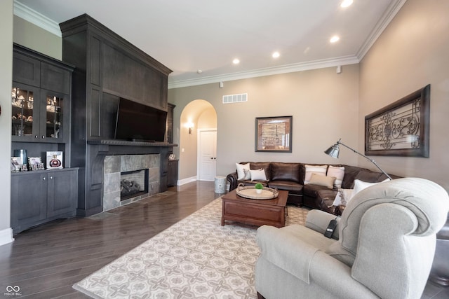 living room featuring crown molding, a fireplace, and dark hardwood / wood-style flooring