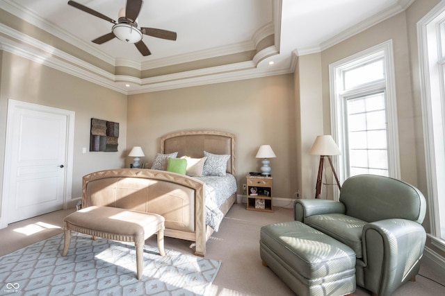 carpeted bedroom with ceiling fan, ornamental molding, and a tray ceiling