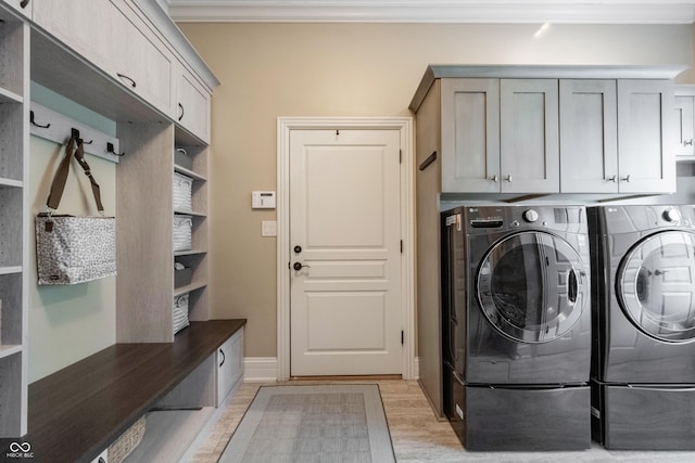 laundry area with cabinets, ornamental molding, separate washer and dryer, and light wood-type flooring