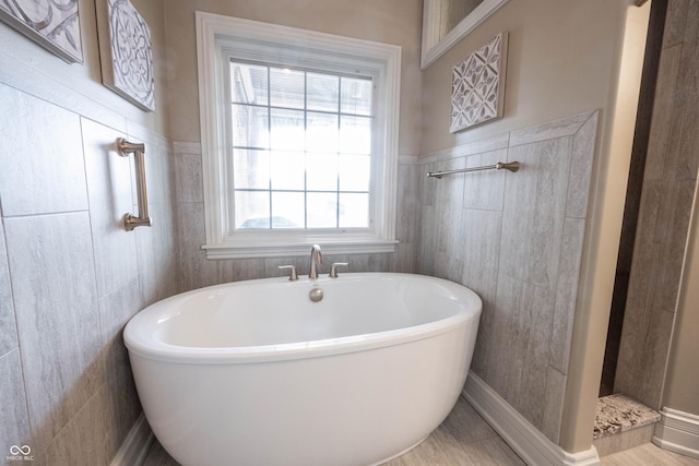 bathroom featuring tile walls and a tub