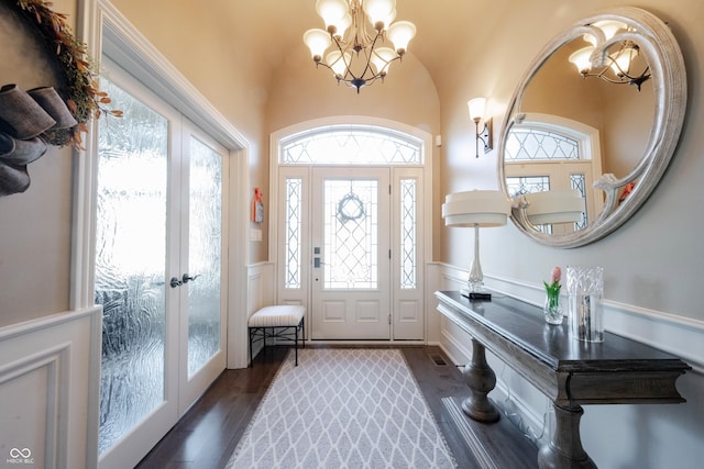 foyer featuring a healthy amount of sunlight, dark hardwood / wood-style floors, french doors, and a chandelier