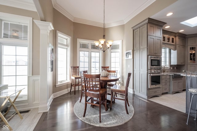 dining area with ornamental molding, hardwood / wood-style floors, and a notable chandelier