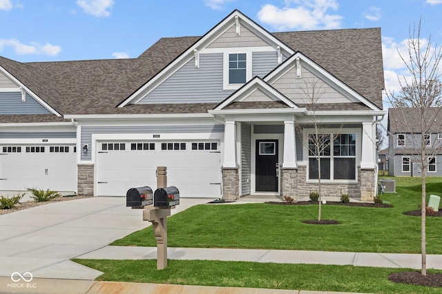 craftsman-style house featuring central air condition unit, a front yard, and a garage