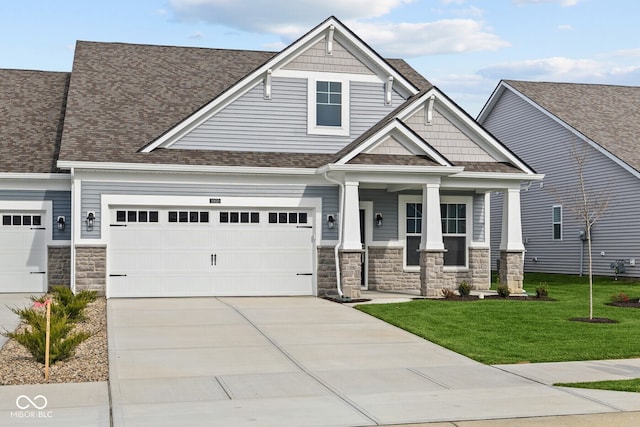 craftsman inspired home with a front lawn, covered porch, and a garage