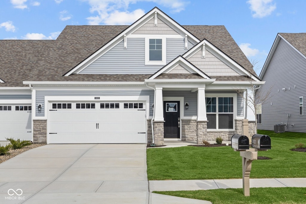 craftsman-style home with central AC, a garage, and a front lawn