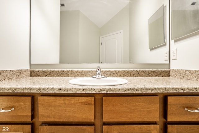 bathroom featuring vanity and vaulted ceiling