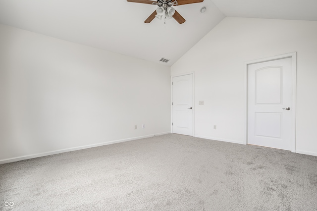 carpeted spare room with ceiling fan and vaulted ceiling