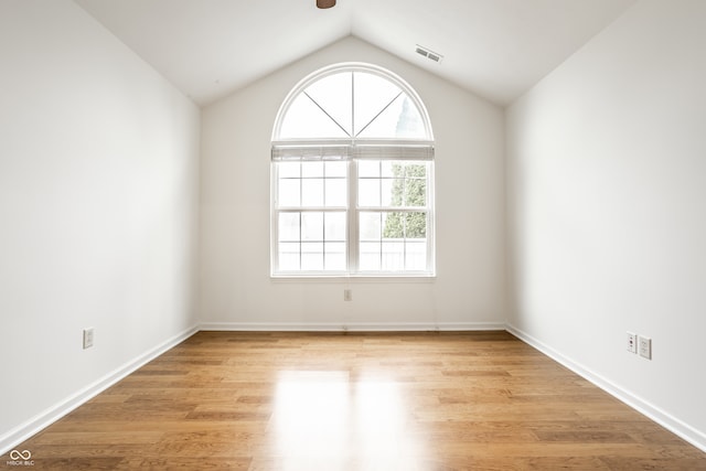 empty room featuring light hardwood / wood-style floors and lofted ceiling