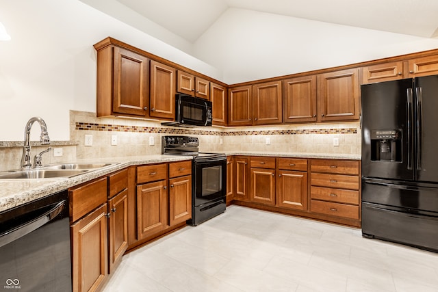 kitchen with sink, tasteful backsplash, lofted ceiling, light tile patterned floors, and black appliances