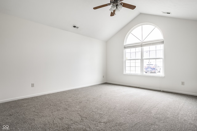 carpeted empty room with a wealth of natural light, ceiling fan, and vaulted ceiling