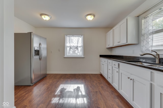 kitchen featuring stainless steel fridge, white cabinets, sink, and plenty of natural light