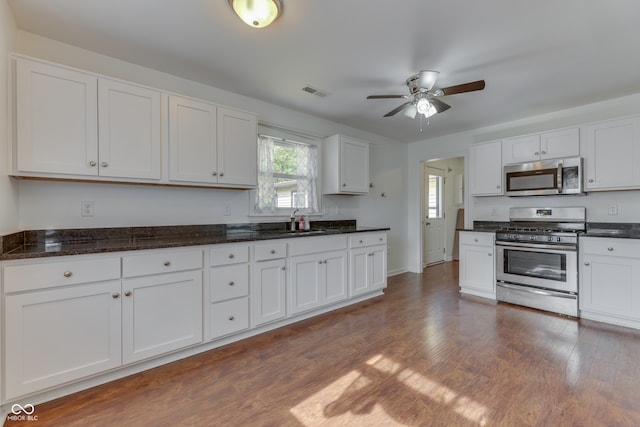 kitchen featuring white cabinets, ceiling fan, stainless steel appliances, and dark hardwood / wood-style flooring