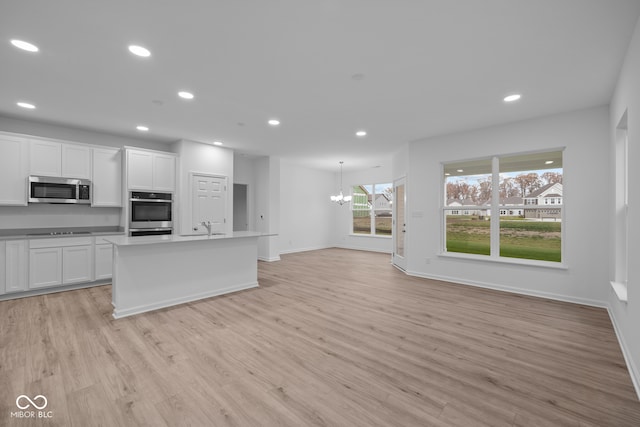 kitchen featuring white cabinetry, a healthy amount of sunlight, light wood-type flooring, and appliances with stainless steel finishes