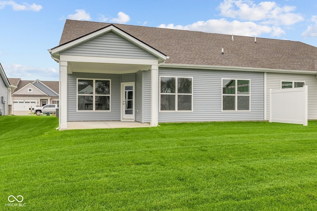 rear view of property featuring a patio area and a lawn