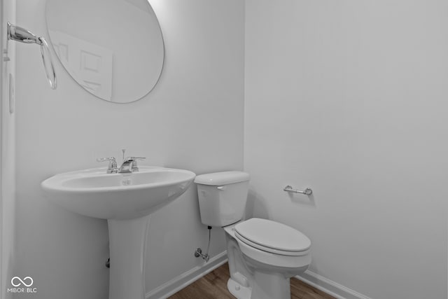 bathroom with wood-type flooring and toilet