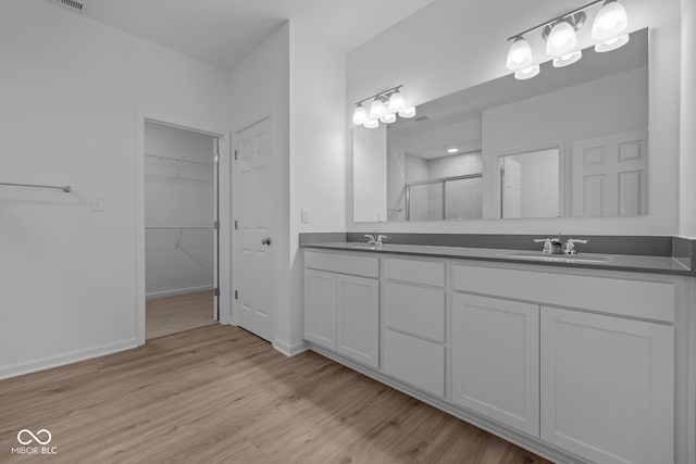 bathroom featuring vanity, an enclosed shower, and wood-type flooring