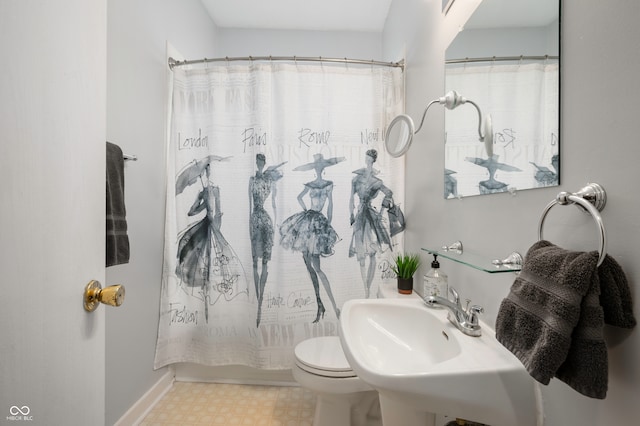 bathroom featuring sink, curtained shower, and toilet