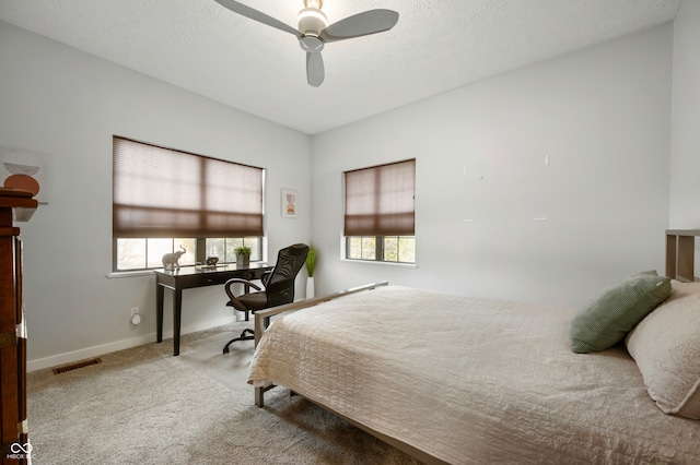 carpeted bedroom with a textured ceiling and ceiling fan