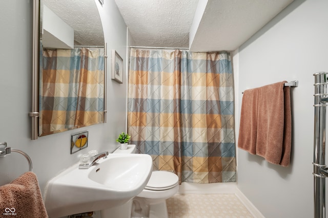 bathroom with toilet, a textured ceiling, walk in shower, and sink