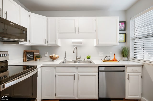 kitchen with sink, appliances with stainless steel finishes, white cabinetry, and a healthy amount of sunlight