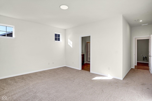 carpeted spare room featuring recessed lighting, baseboards, and a wealth of natural light