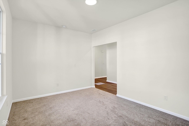 unfurnished room featuring baseboards and carpet