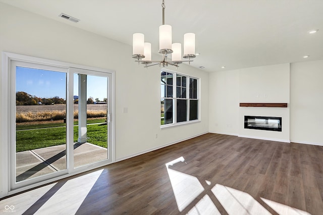 unfurnished living room featuring dark wood-type flooring and an inviting chandelier