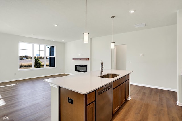 kitchen with sink, stainless steel dishwasher, dark hardwood / wood-style floors, and hanging light fixtures