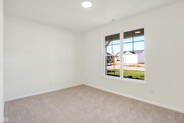 carpeted spare room with baseboards and visible vents