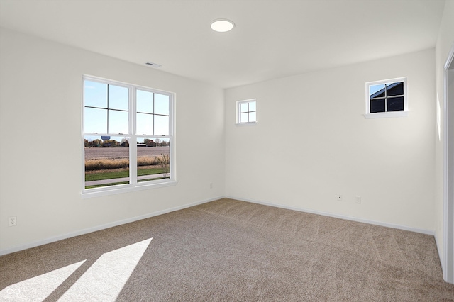 carpeted spare room with baseboards and visible vents