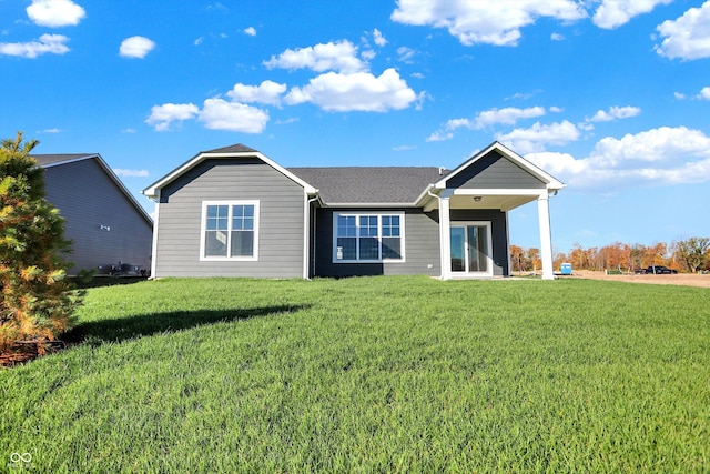 ranch-style home with a shingled roof and a front yard