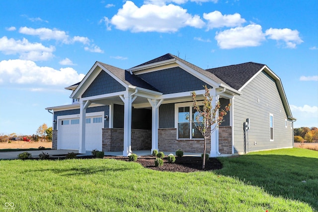view of front of house with a porch, driveway, a front yard, an attached garage, and stone siding
