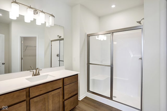 bathroom featuring vanity, wood-type flooring, and a shower with door