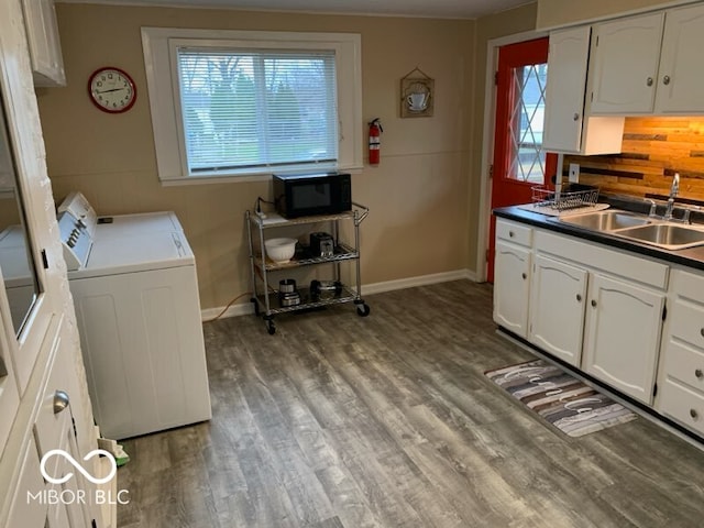 laundry area featuring washer and dryer, hardwood / wood-style flooring, and sink