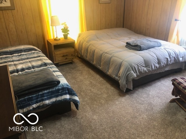 carpeted bedroom with wood walls