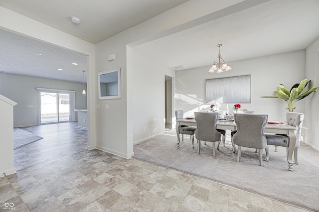 carpeted dining area featuring a chandelier