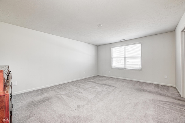 carpeted spare room with a textured ceiling