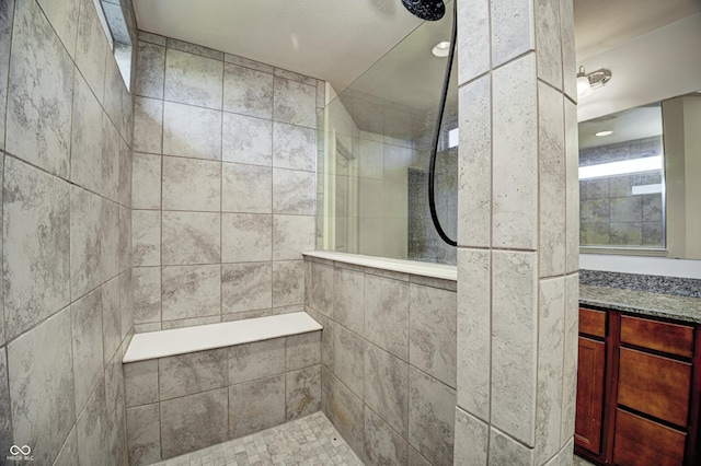 bathroom with vanity and tiled shower