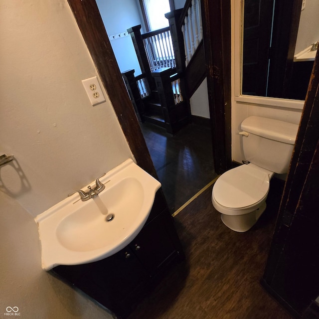 bathroom featuring vanity, toilet, and hardwood / wood-style floors