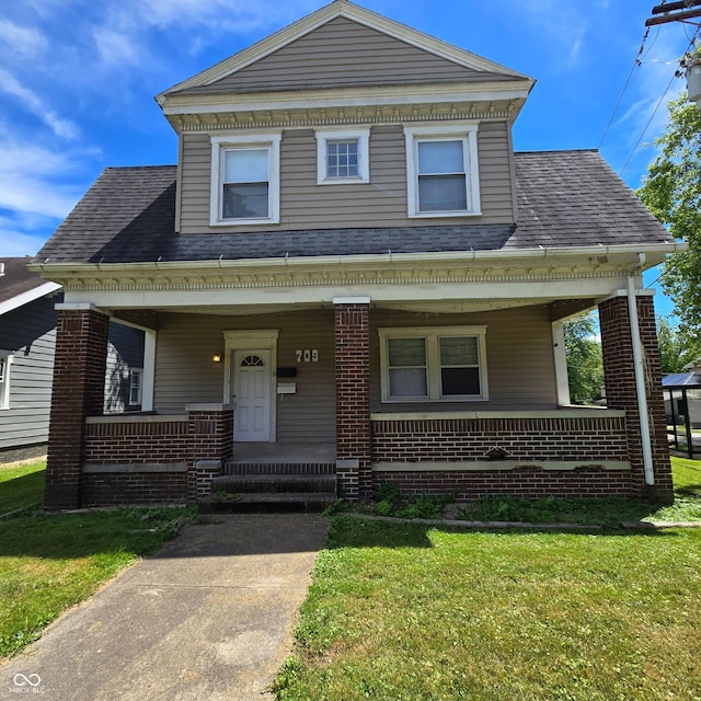 view of front of property with a porch and a front lawn