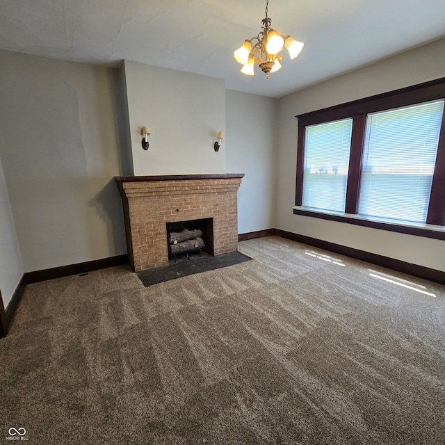 unfurnished living room featuring a notable chandelier, carpet floors, and a brick fireplace