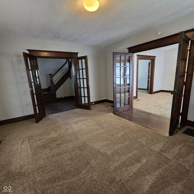 empty room with french doors, dark hardwood / wood-style floors, and a textured ceiling